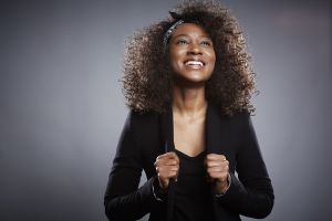 Studio portrait of young businesswoman with fists clenched