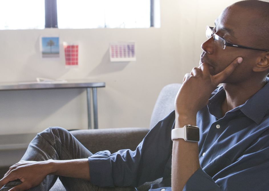 Mixed race businessman thinking in office
