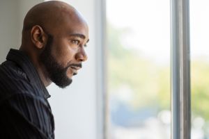 Black man looking out window